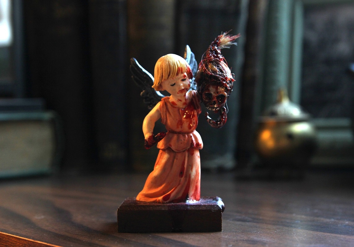 Hero image showing a gruesome angel figurine holding a skull by it's hair.